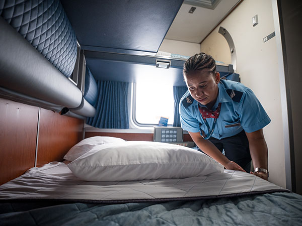 An atendant turns down a bed during the day